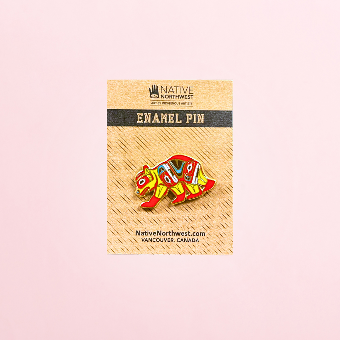 A pin of a bear with colourful designs.