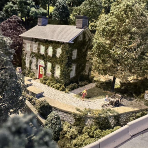 A miniature display of a building with a printing press to the right of it.