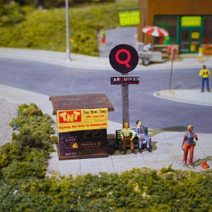 A miniature scene of a news stand with two figures sitting on a bench next to it.