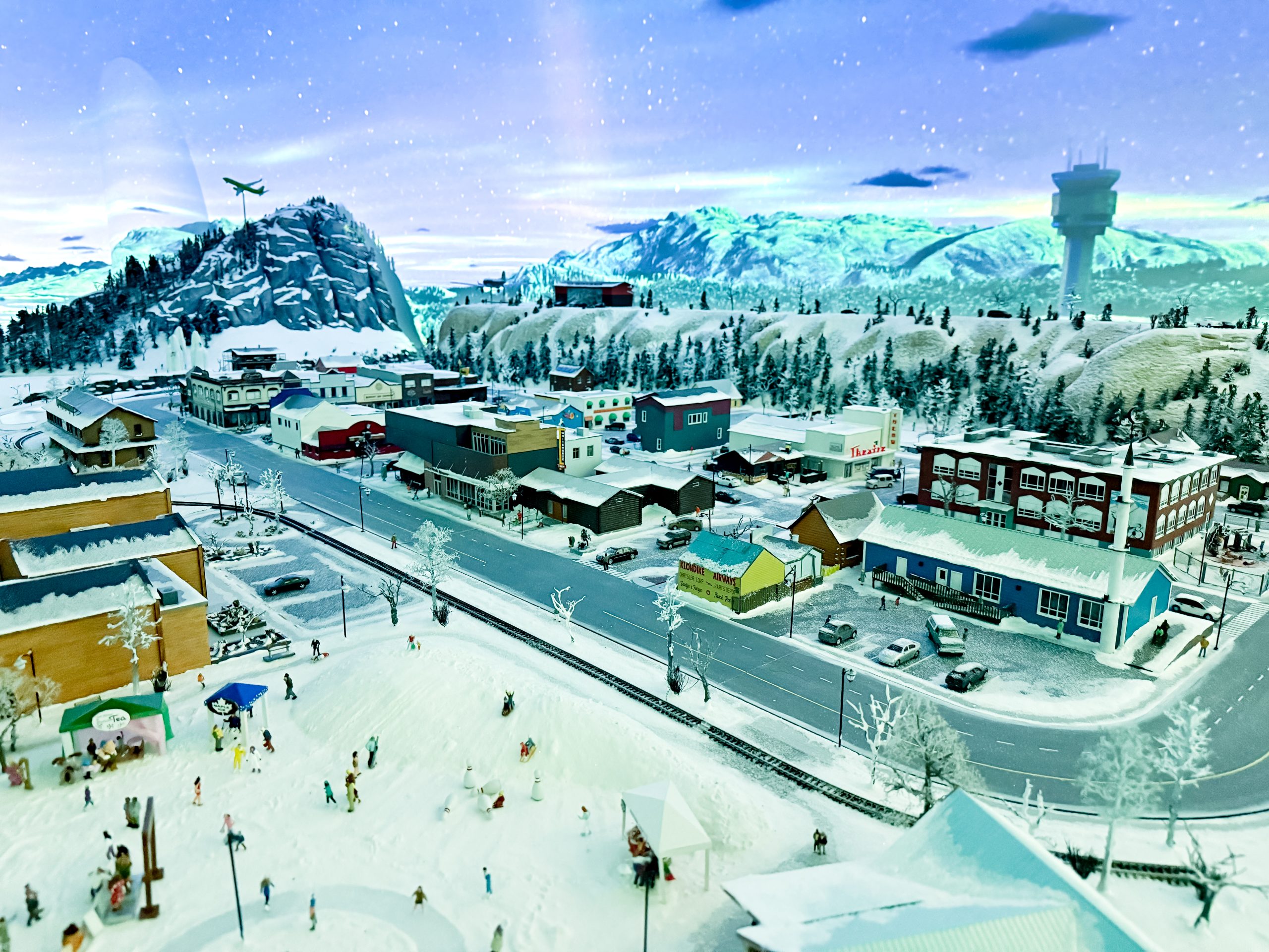 A miniature display of a town with snow-covered buildings and streets.